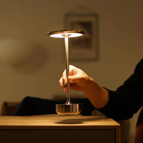 Stijlvolle draadloze tafellamp vastgehouden door een hand, ideaal voor flexibel gebruik