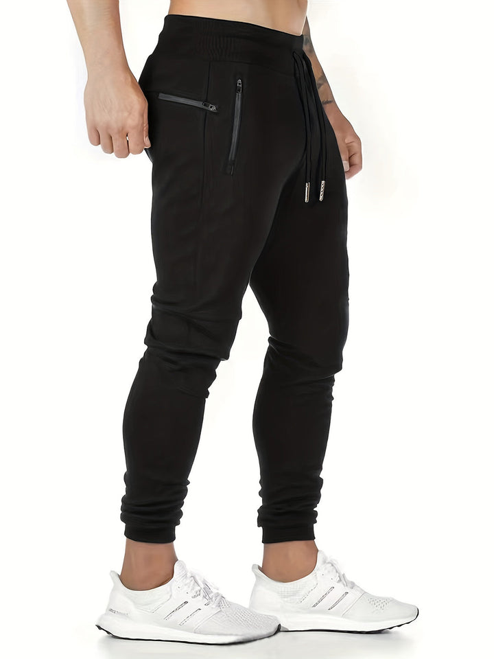 "Kastanjebruine heren joggingbroek van lichtgewicht polyester met ritszakken en trekkoord, ideaal voor lente en herfst."