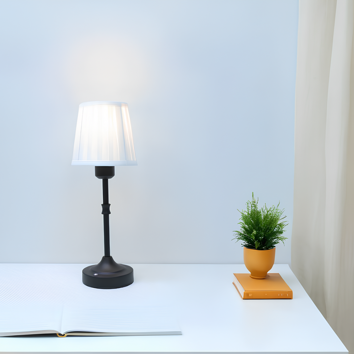 "Klassieke tafellamp met metalen frame en stoffen kap in een interieur, draadloos met drie lichtstanden."