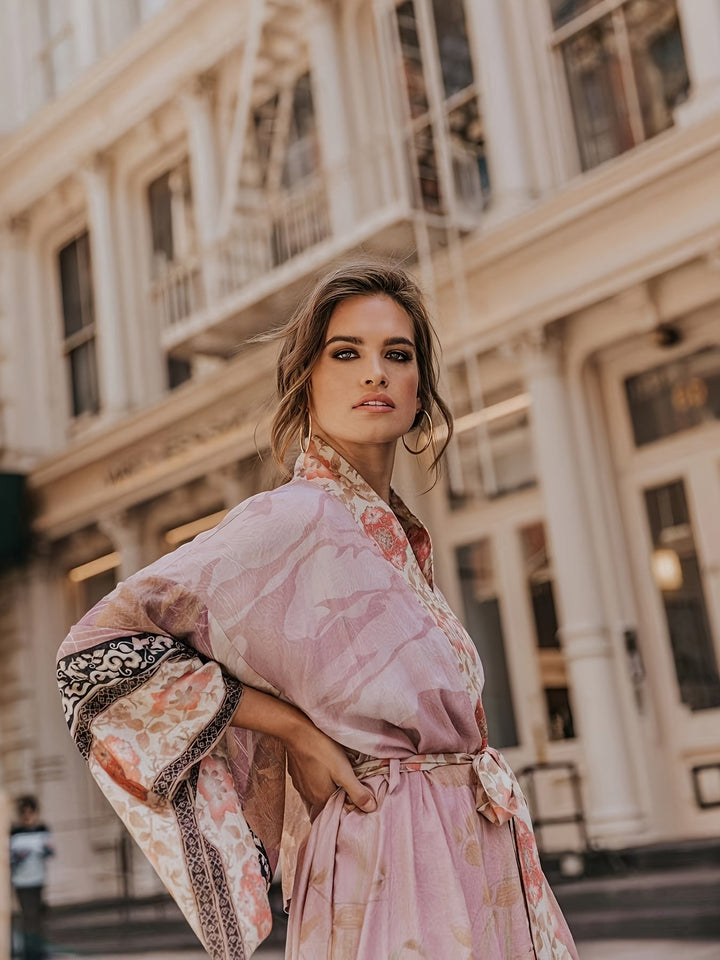 "Lange kimono dames met subtiele bloemenprint en zachte stof, vloeiende pasvorm en ceintuur in taille."