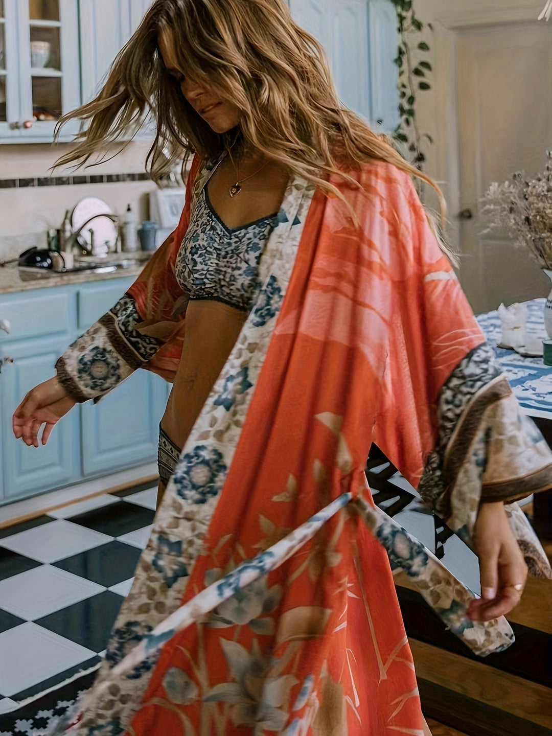 "Lange kimono dames met subtiele bloemenprint en zachte stof, vloeiende pasvorm en ceintuur in taille."