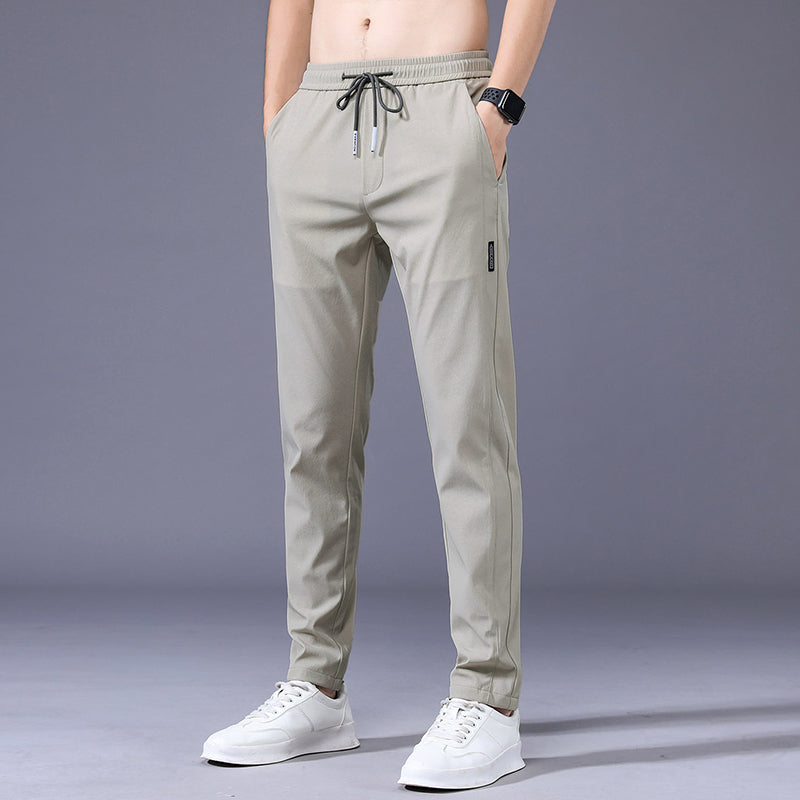Lichtgrijze heren sportjoggingbroek met elastische tailleband, gedragen door een man, perfect voor comfort.