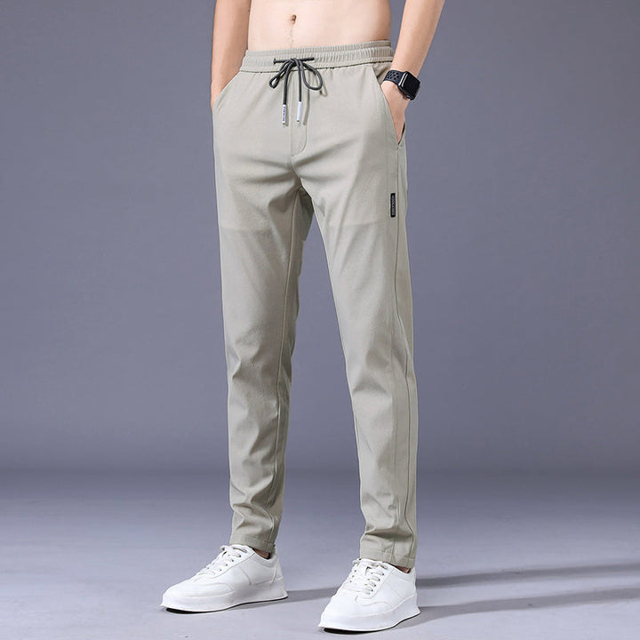 Lichtgrijze heren sportjoggingbroek met elastische tailleband, gedragen door een man, perfect voor comfort.