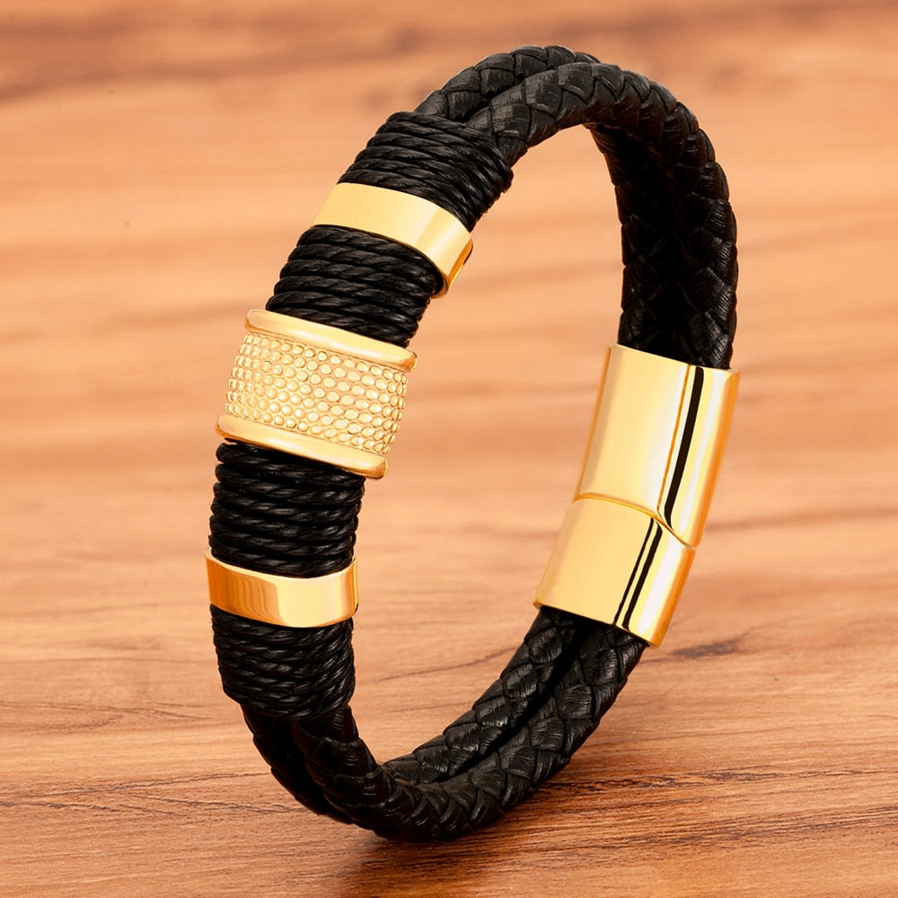 Close-up van stijlvolle gevlochten leren herenarmband met glimmende RVS magneetsluiting.