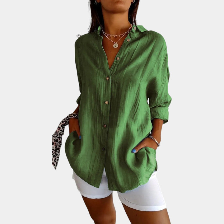 Vrouw draagt een groene damesblouse met lange mouwen en knopen