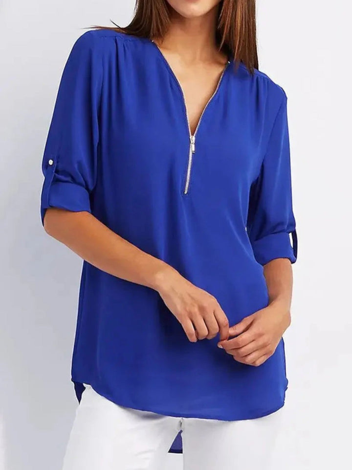 "Luchtige Emilia zomerblouse met v-hals en halve rits in zachte stof, ideaal voor casual zomeroutfits."