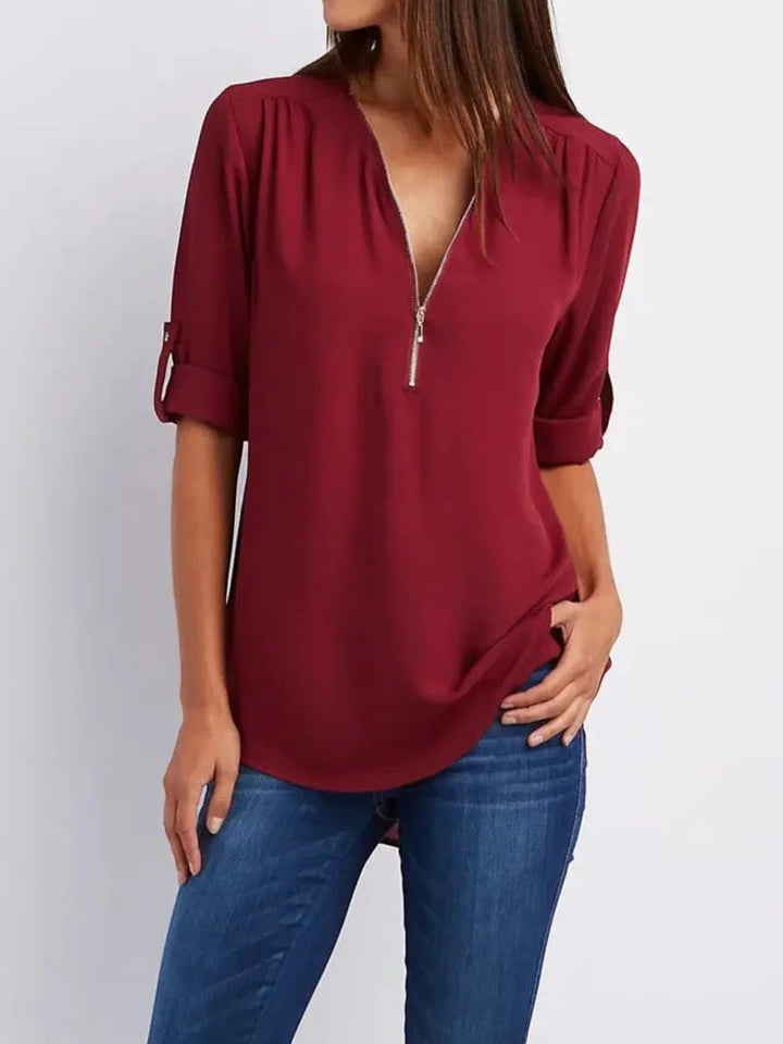 "Luchtige Emilia zomerblouse met v-hals en halve rits in zachte stof, ideaal voor casual zomeroutfits."