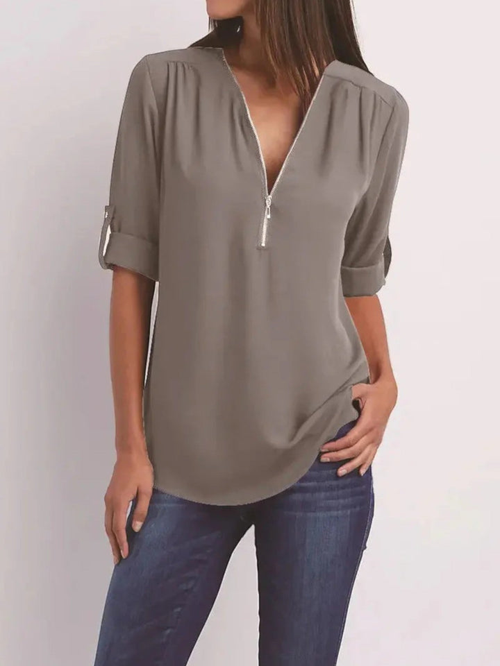 "Luchtige Emilia zomerblouse met v-hals en halve rits in zachte stof, ideaal voor casual zomeroutfits."