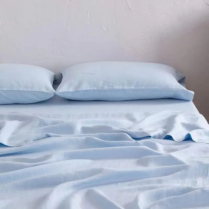 "Luxe linnen beddengoed, elegant en zacht, in diverse kleuren zoals abrikoos en donkergrijs. Perfect voor stijlvol comfort."