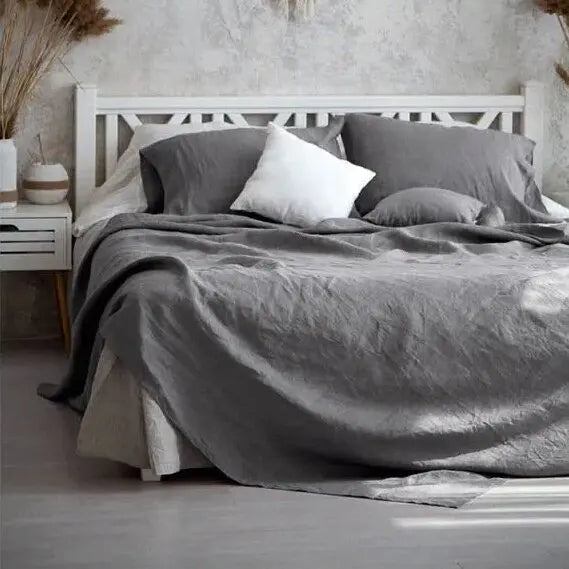 "Luxe linnen beddengoed, elegant en zacht, in diverse kleuren zoals abrikoos en donkergrijs. Perfect voor stijlvol comfort."