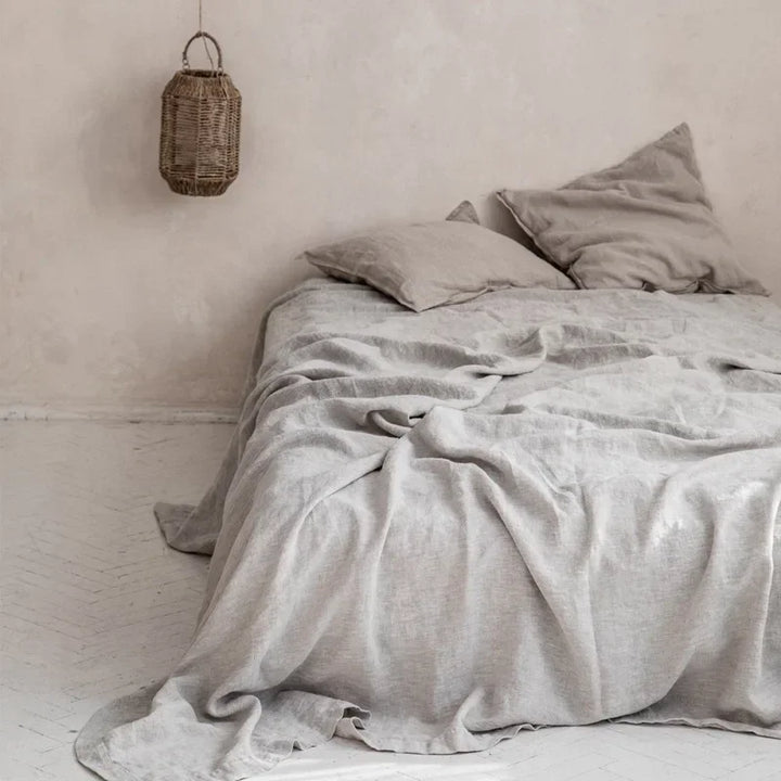 "Luxe linnen beddengoed, elegant en zacht, in diverse kleuren zoals abrikoos en donkergrijs. Perfect voor stijlvol comfort."