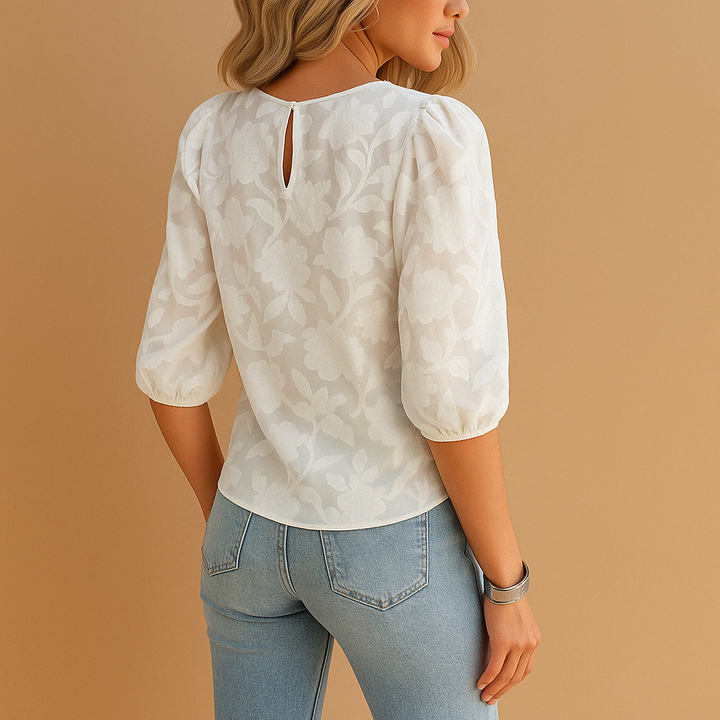 Trendy damesblouse met levendige bloemenprint en opvallende pofmouwen, geschikt voor veelzijdige outfits.
