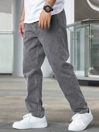 Man draagt grijze straight fit herenjeans met witte sneakers en wit t-shirt