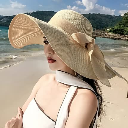 Vrouw met elegante beige zonnehoed op het strand