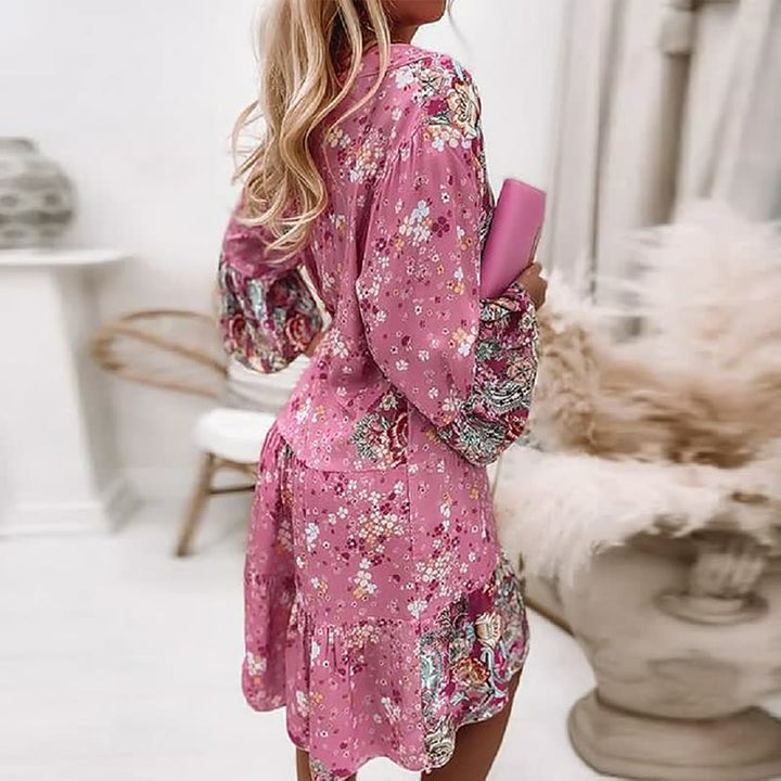 Detailopname van de kleurrijke bloemenprint en ruches aan de zoom van de boho jurk.