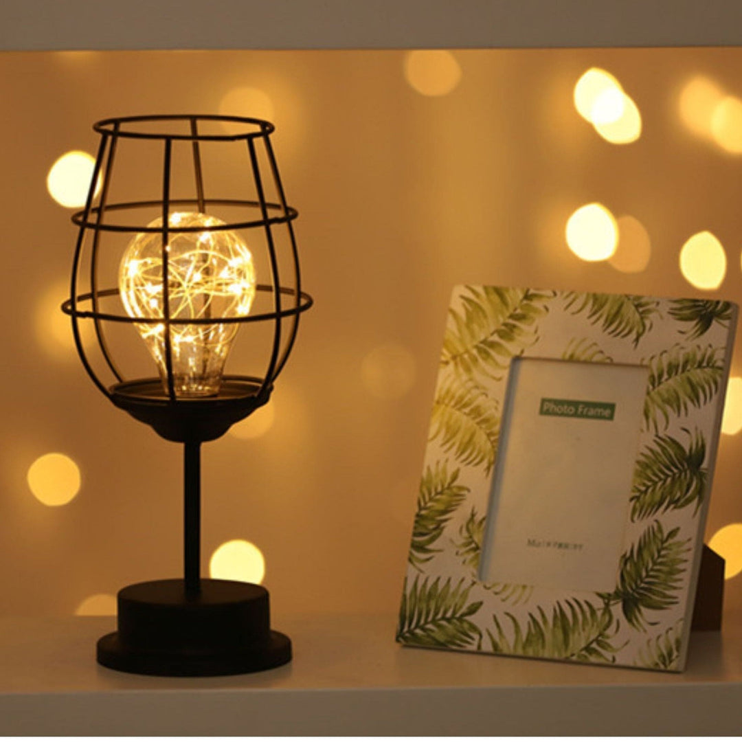 "Rustieke tafellamp met industrieel ontwerp, straalt warm licht uit, ideaal voor sfeerverlichting in moderne interieurs."