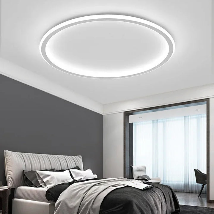 "Scandinavische ronde LED plafondlamp met minimalistisch ontwerp, metalen behuizing, glazen kap, past in modern interieur."