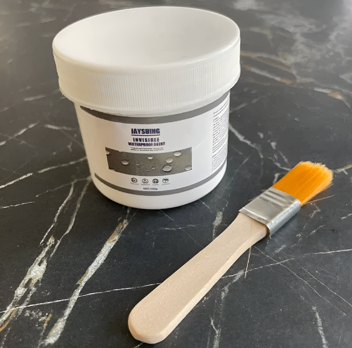 Waterdichte coating pot en kwast op een donkere ondergrond