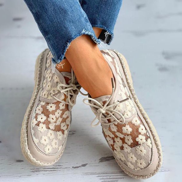 Stijlvolle beige geborduurde damessneakers Liz getoond aan de voeten