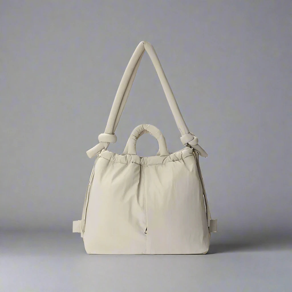 "Stijlvolle puffer handtas in beige met ruim design en comfortabele handgrepen voor vrouwen, perfect voor dagelijks gebruik."