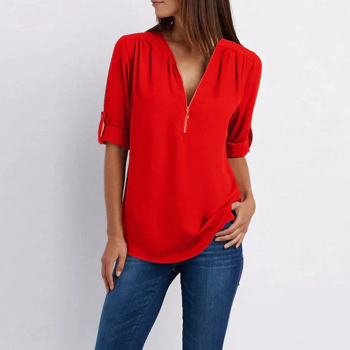 Stijlvolle Vera damesblouse met V-hals en rits in blauw, perfect voor diverse outfits en gelegenheden.