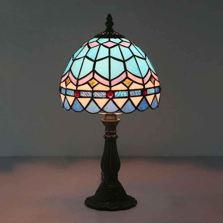 "Tiffany-stijl tafellamp, blauw en geel glas, klassieke loodlijnen, warme en uitnodigende sfeer, ambachtelijk design."