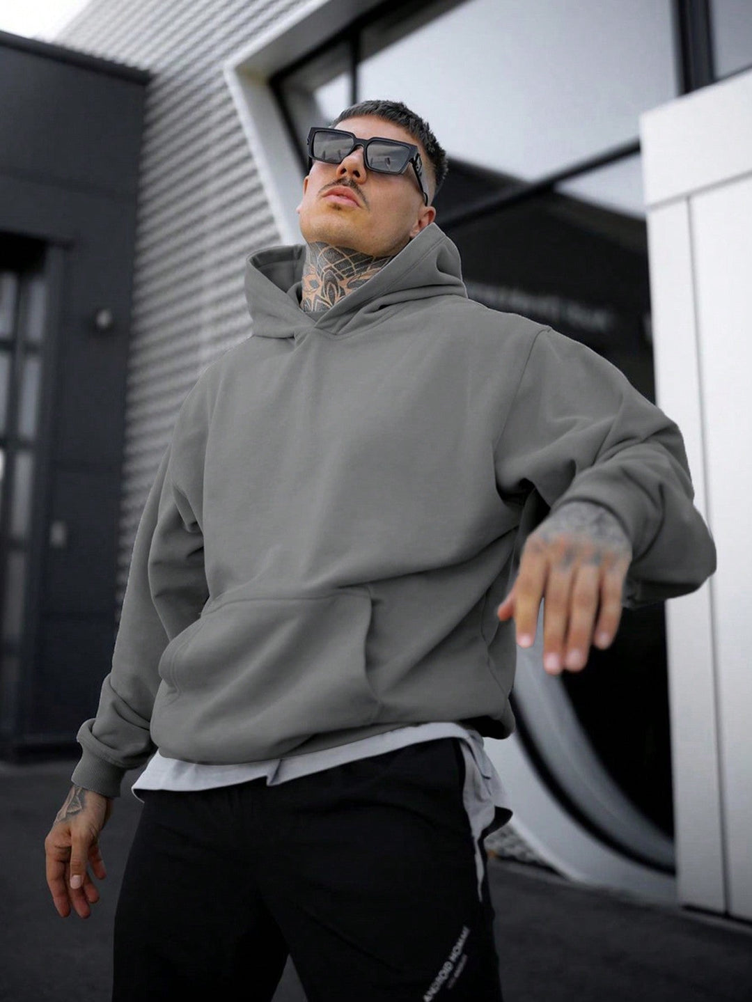 Man draagt donkergrijze Tim heren hoodie met oversized pasvorm en capuchon