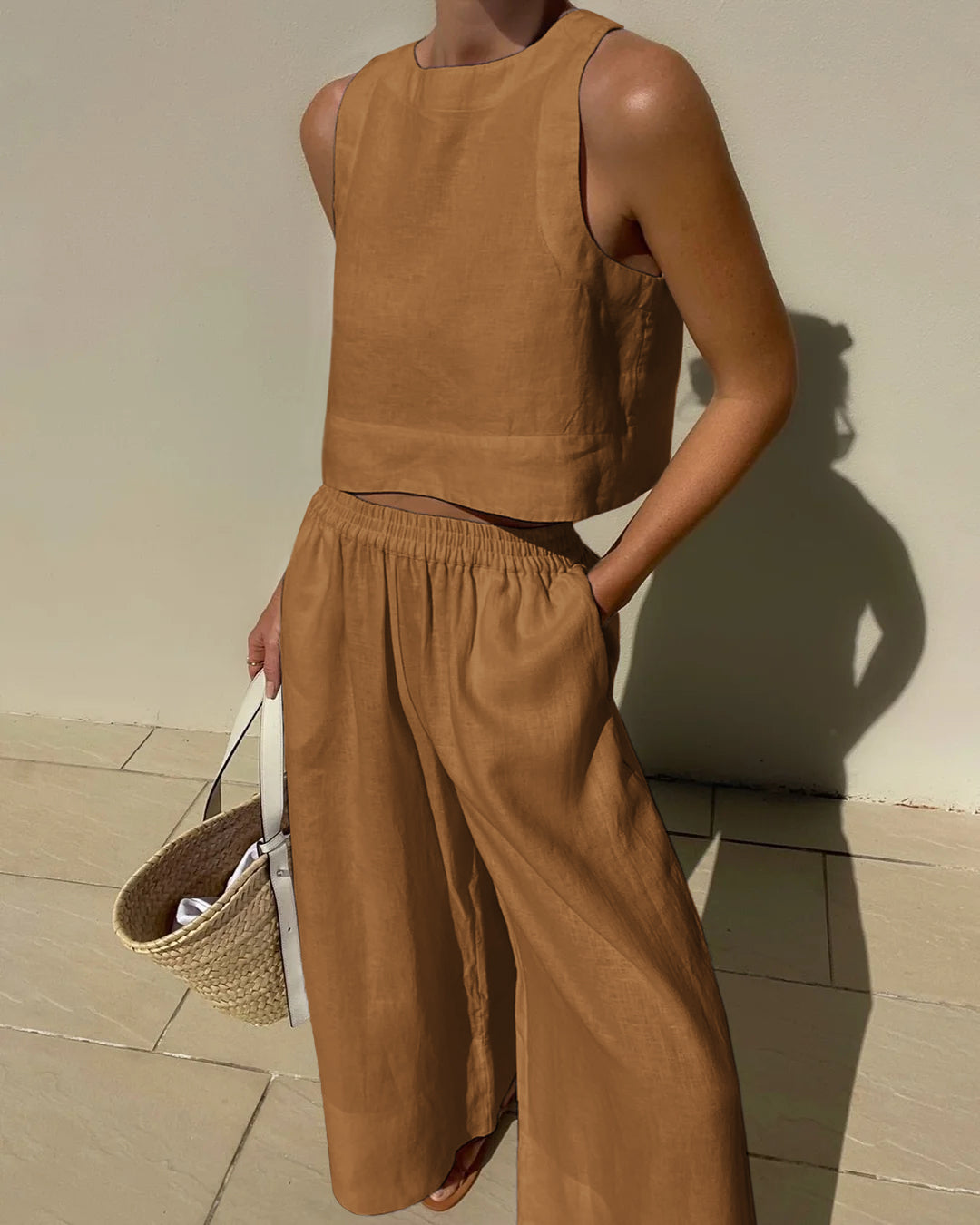 "Tweedelige dames set, elegante mouwloze crop top en wijde broek, ideaal voor zomer, stijlvol en verfijnd in beige."