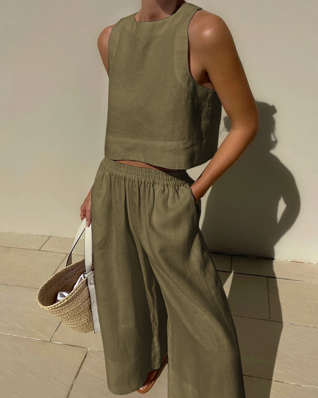 "Tweedelige dames set, elegante mouwloze crop top en wijde broek, ideaal voor zomer, stijlvol en verfijnd in beige."