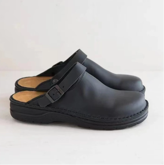 Man draagt comfortabele heren instappers, gesloten pantoffels thuis. Perfect voor ontspanning en casual gebruik.