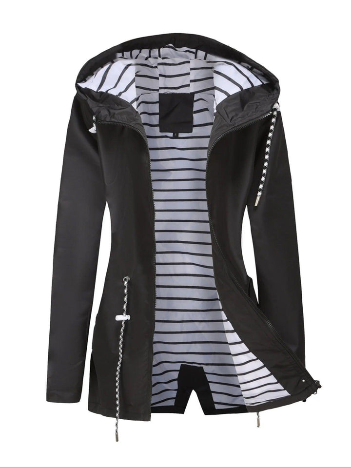 "Weerbestendige damesjas met capuchon in herfstkleuren, wind- en waterdicht, perfect voor regenachtig weer."