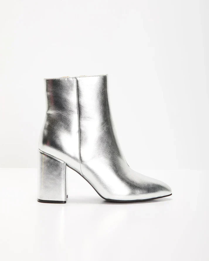 Zilveren metallic enkellaars met glamour blokhak, puntige neus en ritssluiting. Verhoog je stijl met deze elegante laarsjes.